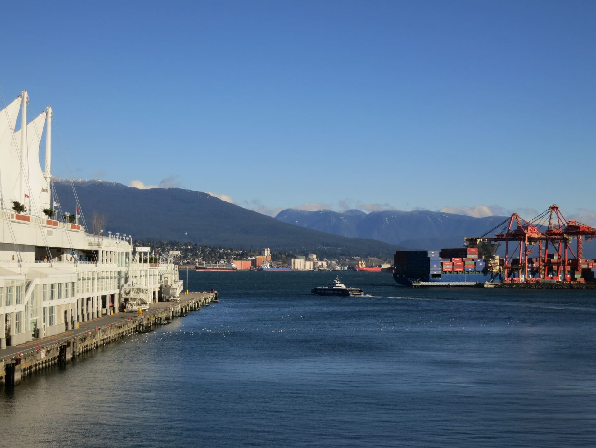 Canada Place and the container cranes of the Port of Vancouver across Burrard Inlet.