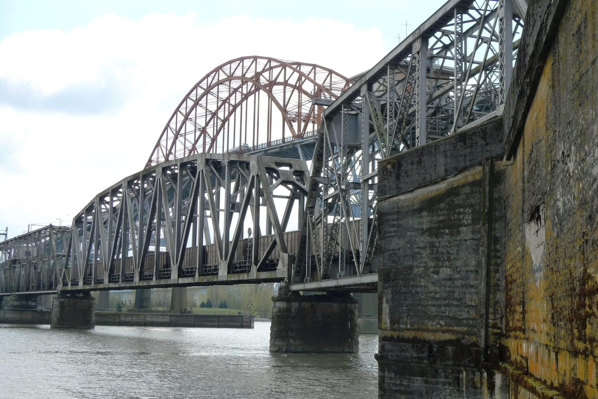 The steel truss spans of the New Westminster rail swing bridge over the Fraser River.